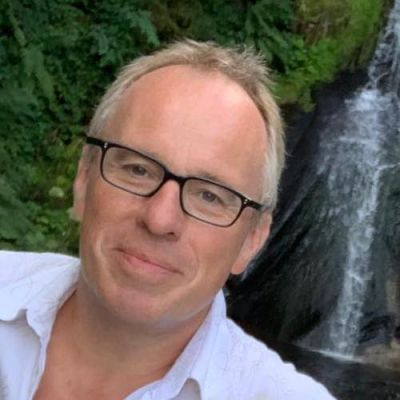 Andrew Bottrill wears a white shirt and black glasses